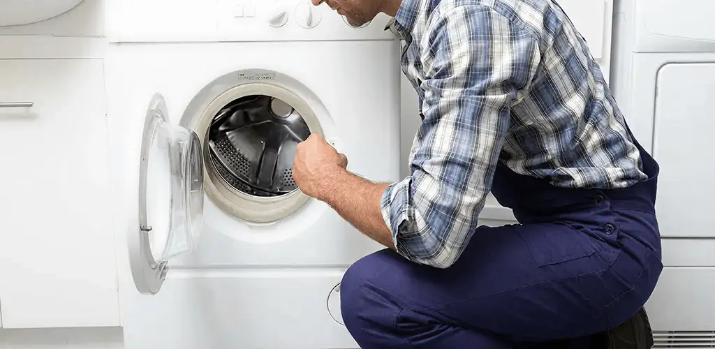 Handyman inspecting a dryer drum and internal parts for repair in Pasadena, CA