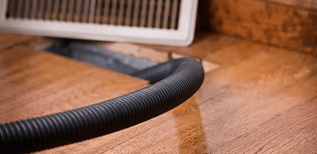Air duct cleaning hose inserted into a floor vent for ductwork cleaning in Pasadena, CA