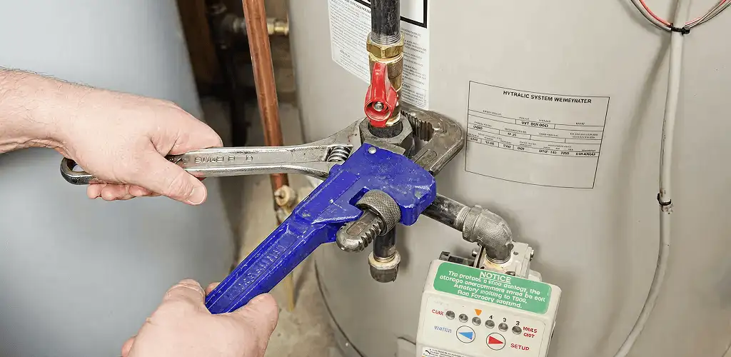 Water heater repair technician tightening the shutoff valve and supply line in Pasadena, CA